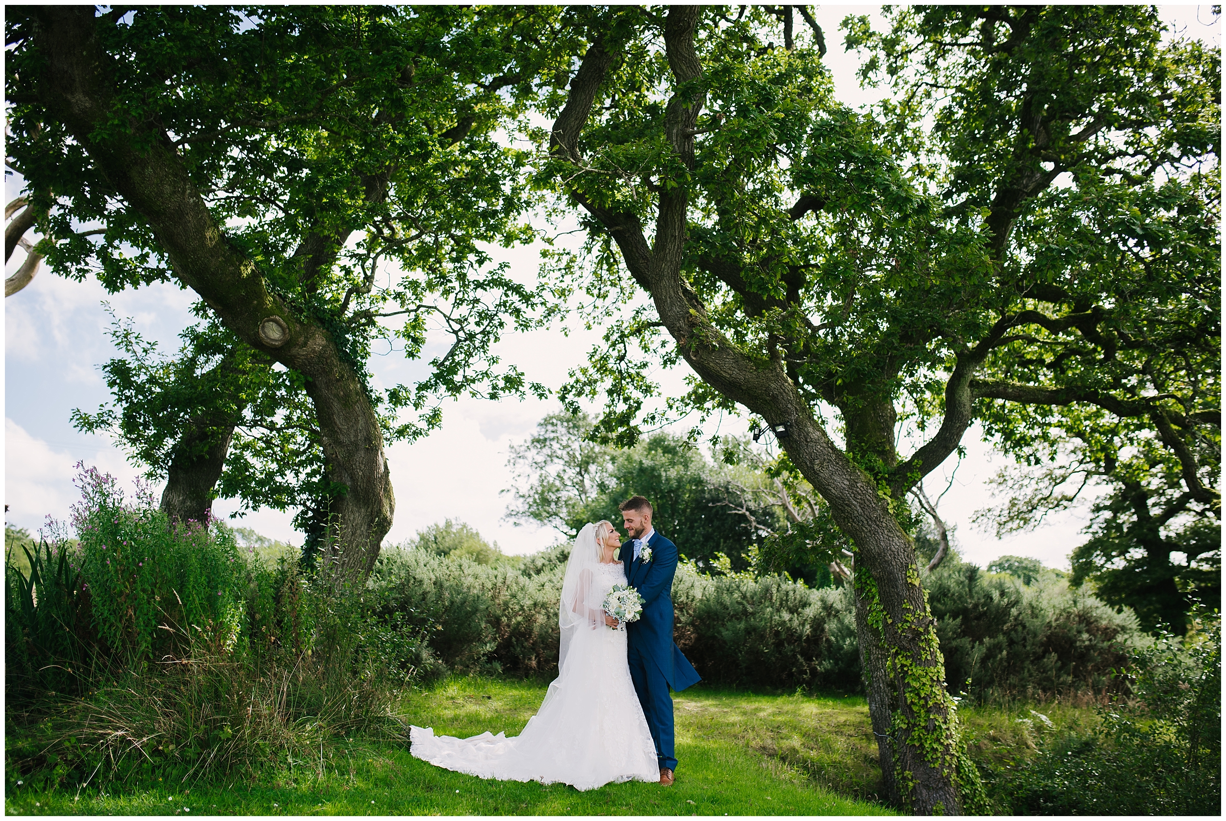 Bride and groom under trees at Oldwalls Gower wedding venue